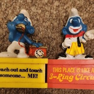 2 Vintage Smurf Peyo Schleich Figurines Smurfagrams atop a stand